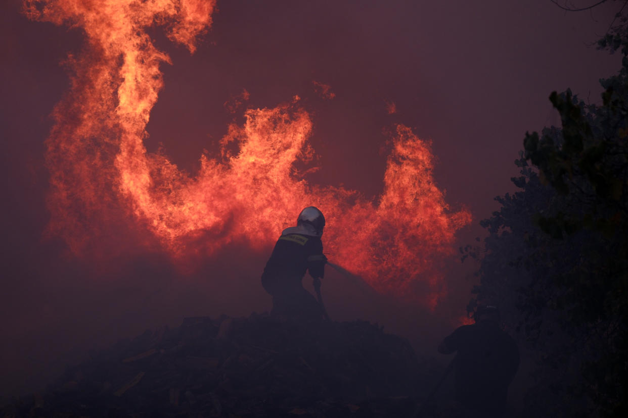 A firefighter tries to extinguish the flames at a business in northern Athens on Monday. 