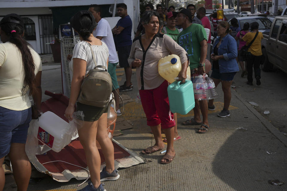 People wait in line with containers to buy gasoline, in the aftermath of Hurricane Otis, in Acapulco, Mexico, Saturday, Oct. 28, 2023. (AP Photo/Felix Marquez)