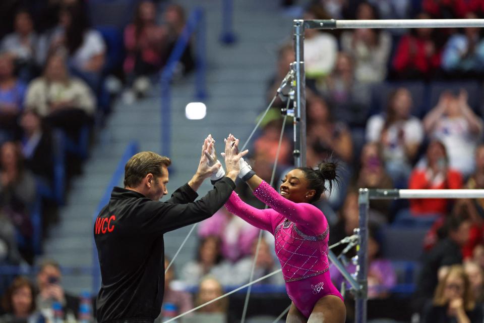 US gymnast Simone Biles (R) is congratulated by coach Laurent Landi after competing in the uneven bars event during the Core Hydration Classic at XL Center in Hartford, Connecticut, on May 18, 2024. (Photo by Charly TRIBALLEAU / AFP) (Photo by CHARLY TRIBALLEAU/AFP via Getty Images)