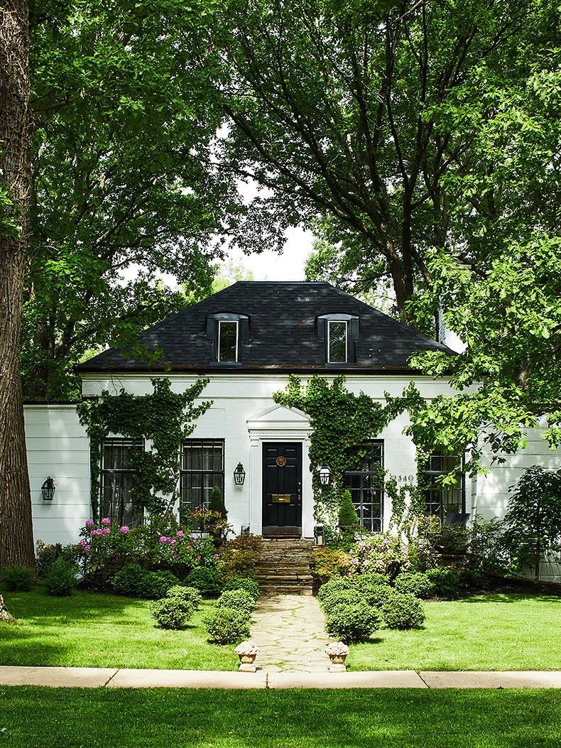 stately house with black roof and white facade