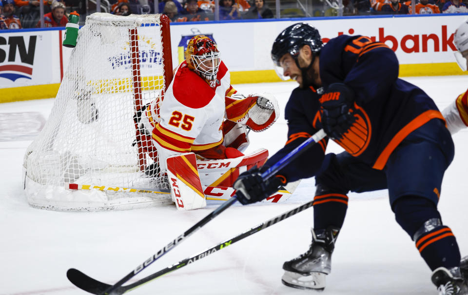 Calgary Flames goalie Jacob Markstrom, left, keeps an eye on Edmonton Oilers center Derek Ryan during the second period of Game 4 of an NHL hockey Stanley Cup playoffs second-round series Tuesday, May 24, 2022, in Edmonton, Alberta. (Jeff McIntosh/The Canadian Press via AP)