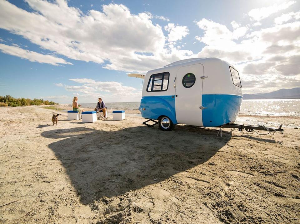The trailer on a beach near people.