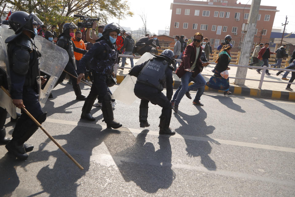 Pro-king supporters clash with riot police as they march demanding reinstating monarchy that was abolished more than a decade ago in Kathmandu, Nepal, Monday, Jan.11, 2021. Monday's protest was the latest anti-government protest against Prime Minister Khadga Prasad Oli who has been facing street demonstrations against him from a splinter faction of his own Communist party and more from opposition political groups for dissolving parliament. Nepal's centuries-old monarchy was abolished in 2008 by the parliament and replaced by a republic where the president was elected as the head of state. (AP Photo/Niranjan Shrestha)
