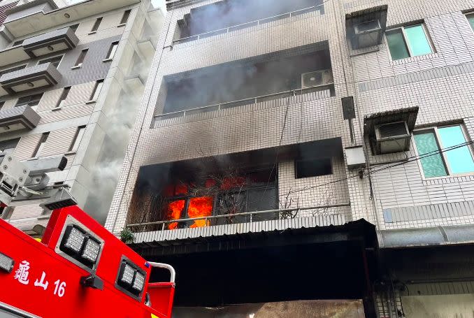 ▲桃園市龜山區自強南路一處民宅，今（26）日上午10時許突發大火，消防局獲報趕赴現場救援，現場1樓全面燃燒，其中受困3樓的15歲未成年少年被救出時，已經沒有生命跡象，而受困4樓的2人由雲梯車救出，3人皆送往醫院搶救。（圖／翻攝畫面）