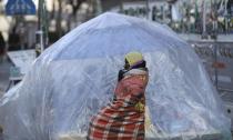 In this Wednesday, Jan. 11, 2017 photo, a tent made of plastic sheet is set by students to protect a statue of a girl representing thousands of Korean women enslaved for sex by Japan's imperial forces before and during World War II, during a rally in front of the Japanese Embassy in Seoul, South Korea. Some young protesters have been camping for more than a year near the small bronze statue of a girl, determined to protect a symbol that plays an outsized role in the relations between Seoul and Tokyo. (AP Photo/Lee Jin-man)