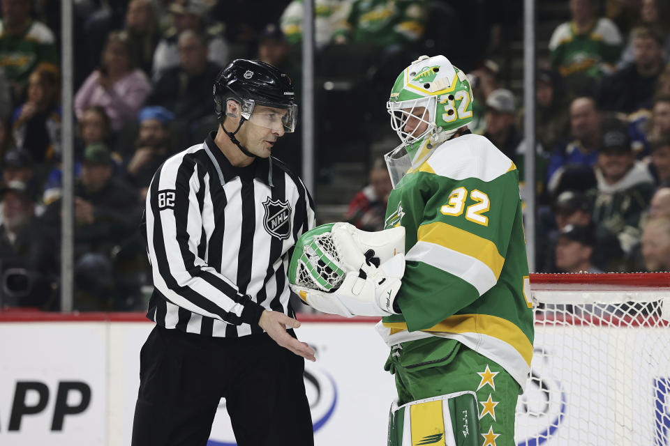 Minnesota Wild goaltender Filip Gustavsson (32) hands the puck to linesman Ryan Galloway (82) during the first period of an NHL hockey game against the St. Louis Blues, Sunday, Jan. 8, 2023, in St. Paul, Minn. (AP Photo/Stacy Bengs)