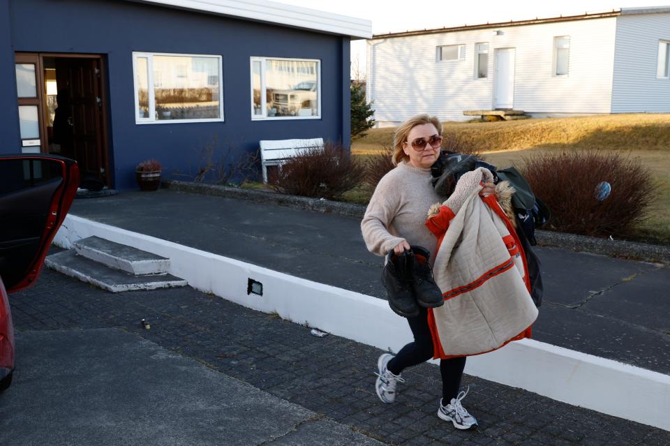 A resident from the town of Grindavik, Iceland, takes some of their belongings from their house (AP)