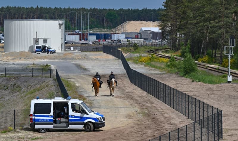 Two officers of the mounted police are on the road with their horses on the Tesla factory premises. After violent clashes at the Tesla factory site in Gruenheide near Berlin, the police are preparing for further demonstrations on Saturday. Patrick Pleul/dpa