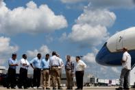 U.S. President Barack Obama (back to camera, 5th L) speaks with local and state officials as he arrives aboard Air Force One at Baton Rouge Metropolitan Airport in Baton Rouge, Louisiana, U.S., August 23, 2016. REUTERS/Jonathan Ernst