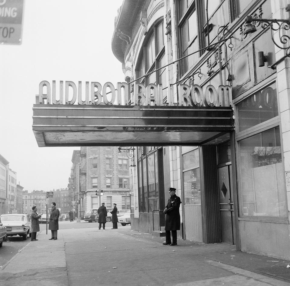 FILE - New York police officers stand outside the Audubon Ballroom on 166th Street at Broadway in the Harlem section of Manhattan, where black Muslim leader Malcolm X was assassinated as he addressed a rally on Feb. 21, 1965, in New York. Two of the three men convicted in the assassination of Malcolm X are set to be cleared Thursday, Nov. 18, 2021, after insisting on their innocence since the 1965 killing of one of the United States' most formidable fighters for civil rights, Manhattan's top prosecutor said Wednesday, Nov. 17, 2021. (AP Photo)