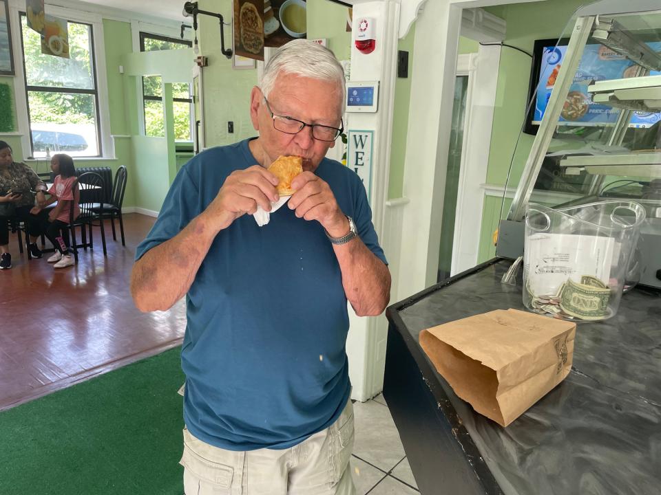 Richard LaFlamme trying a Haitian patty for the first time from Palermo Bakery & Bar.