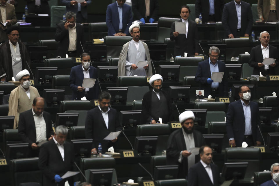 Lawmakers are sworn in during the inauguration of Iran's new parliament, in Tehran, Iran, Wednesday, May, 27, 2020. Iran has convened its newly elected parliament, dominated by conservative lawmakers and under strict social distancing regulations, as the country struggles to curb the spread of coronavirus that has hit the nation hard. Iran is grappling with one of the deadliest outbreaks in the Middle East. (AP Photo/Vahid Salemi)