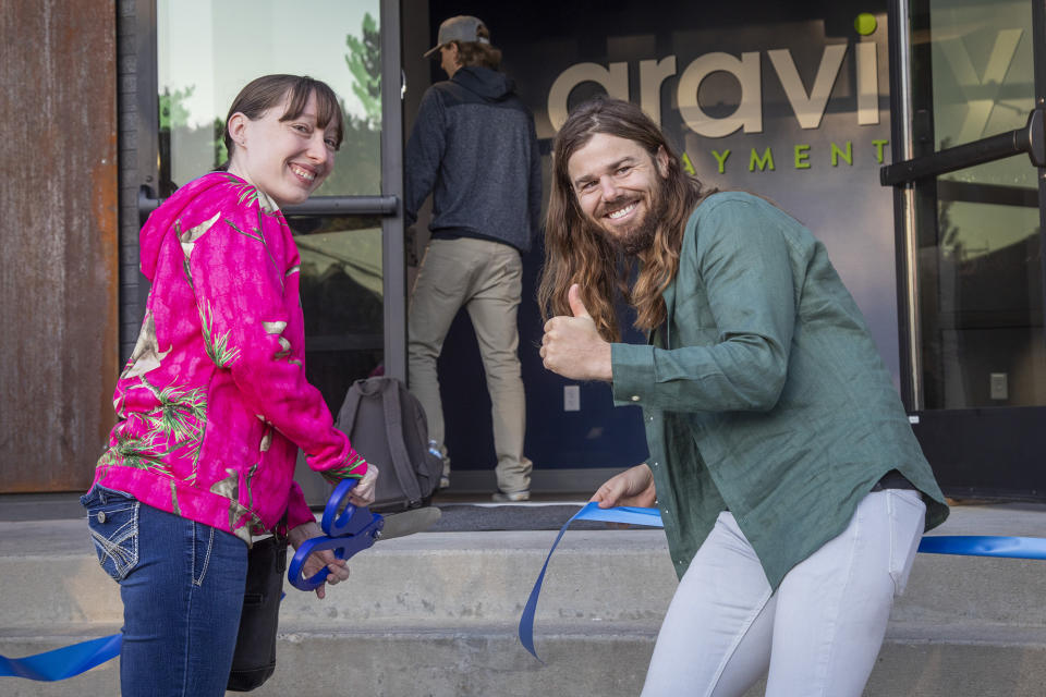 Dan Price, CEO and founder of Gravity Payments, recreates a ribbon-cutting with Rachel Redding, a QA analyst, for social media. (Katherine Jones/Idaho Statesman/Tribune News Service via Getty Images)