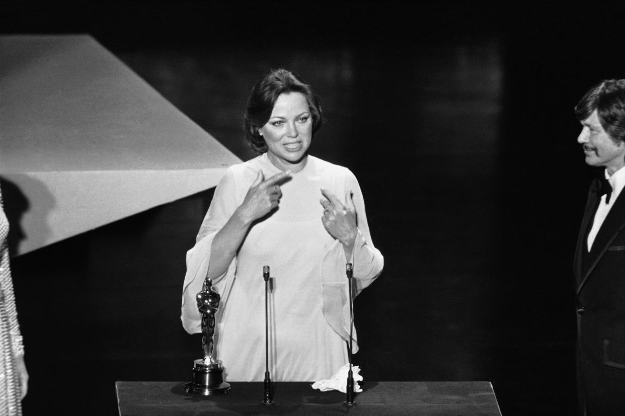 Louise Fletcher uses sign language on the stage on March 29, 1976 in Los Angeles as she thanked her parents for their help in winning the Academy Award Oscar she received for her role in "One Flew Over the Cuckoo's Nest". 
