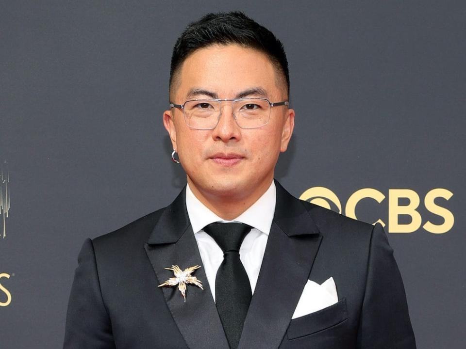 Bowen Yang wears a black suit and heels on the Emmys red carpet.