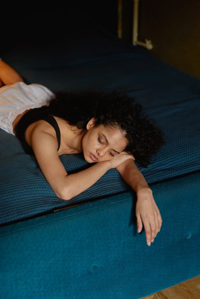 Black woman thinking while laying on the bed