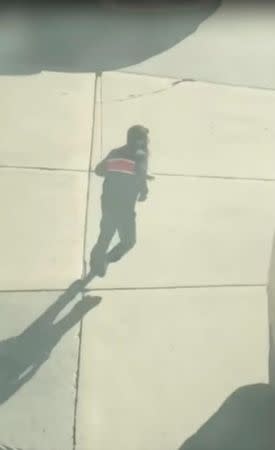 Suspected driver of the pickup truck that mowed down pedestrians and cyclists on a bike path alongside the Hudson River runs after the attack in the middle of a road, in New York City, NY, U.S., in this still image from a video obtained from social media October 31, 2017. TAWHID KABIR XISAN via REUTERS