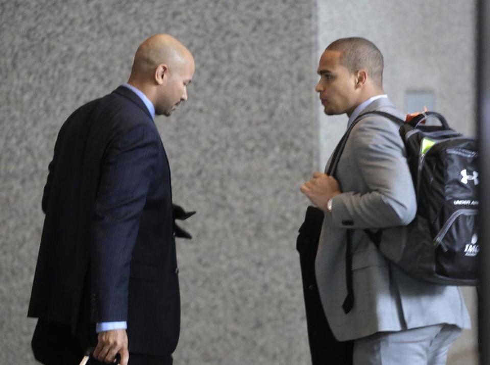 College Athletes Players Association designated president Ramogi Huma, left, and Northwestern University outgoing senior quarterback Kain Colter make their way to the beginning of three days of hearings before the National Labor Relations Board Tuesday, Feb. 18, 2014, in Chicago. The NLRB is scheduled to begin witness testimony on whether to approve a bid by Northwestern University football players who are trying to unionize. Colter is among the key witnesses in the case. (AP Photo/M. Spencer Green)