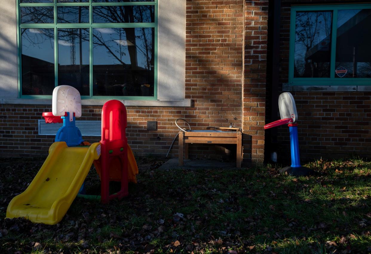 A plastic toy slide and basketball hoop sit on the grass outside the Chapelle Business Center in Ypsilanti on Friday, Dec. 8, 2023.