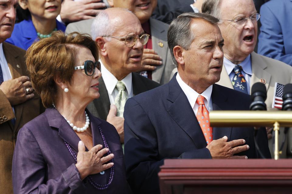 U.S. House Minority Leader Pelosi and House Speaker Boehner sing the national anthem during a remembrance of lives lost in the 9/11 attacks, in Washington