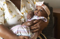 Asian Davis, 33, of Sikeston, Mo., cradles her 8-month-old daughter Mira White during an interview on Oct. 3, 2023, in St. Louis. Davis and her lawyers say Mira suffered brain damage in March after developing bacterial meningitis tied to powdered infant formula contaminated with Cronobacter sakazakii, a germ known to cause severe disease in young babies. (AP Photo/Michael Thomas)