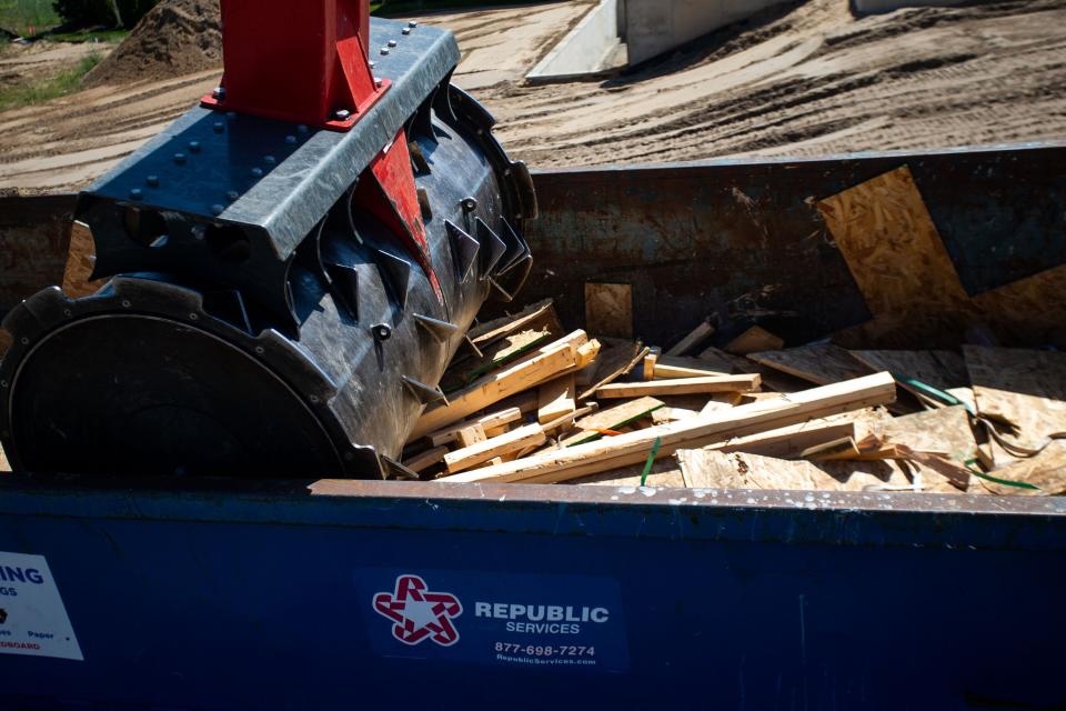 Six hundred pounds of spiked wheel crushes wood scraps from a nearby home construction site on Tuesday, June 21. The wheel, and the truck it's attached to, are owned by Smash My Trash.