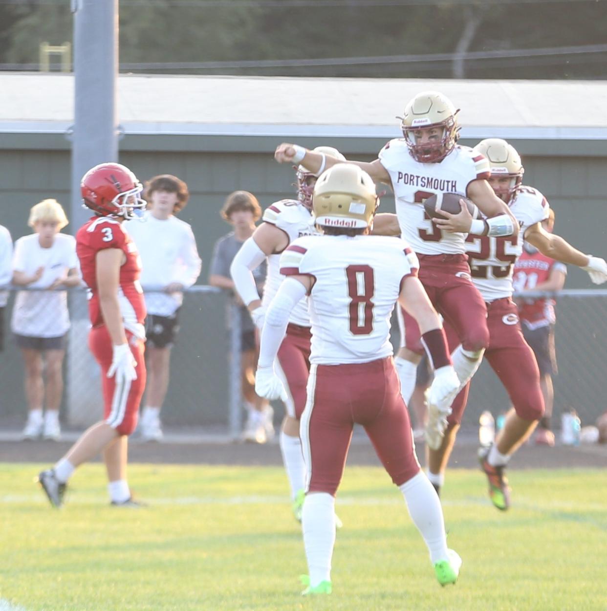 Portsmouth/Oyster River's Dom Buono (3) celebrates with teammates following his first quarter touchdown run in Friday's 40-6 win at Spaulding.