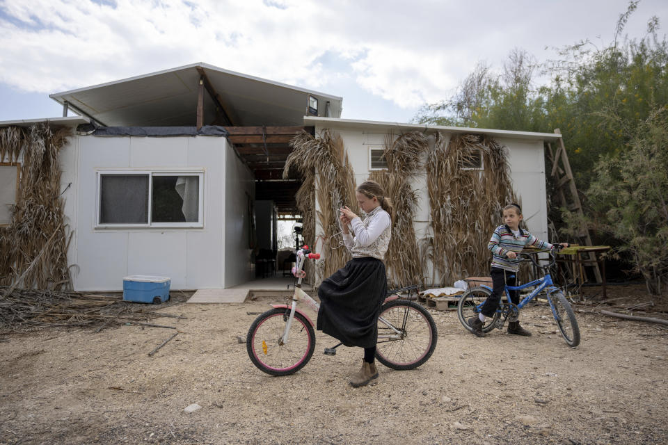 Dos jóvenes colonos judíos juegan frente a su casa en el puesto de avanzada de Beit Hogla, en Cisjordania, el miércoles 15 de febrero de 2023. El nuevo gobierno ultranacionalista de Israel ha declarado que legalizará 10 puestos de avanzada no autorizados en la Cisjordania ocupada. La medida inusual ha intensificado el desafío de las autoridades a la presión internacional y abrió un nuevo frente agresivo en la expansión israelí en Cisjordania, que Israel capturó en la guerra de Oriente Próximo de 1967. (AP Foto/Ohad Zwigenberg)