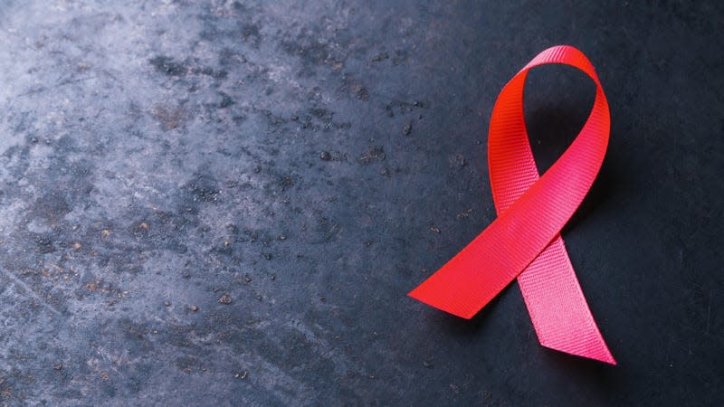 Above, a red AIDS awareness ribbon.