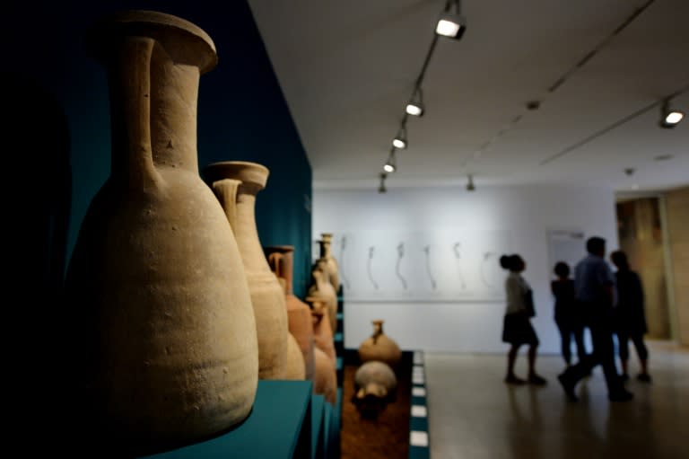 People walk past amphorae used to transport liquids displayed during the exhibition "Feeding the Empire: Tales of food from Rome and Pompei'' at Ara Pacis Museum in Rome on July 25, 2015