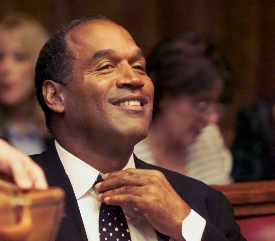 O.J. Simpson adjusts his tie before the jury selection of his trial in Miami-Dade court on Oct. 9, 2001. Al Diaz/Miami Herald File