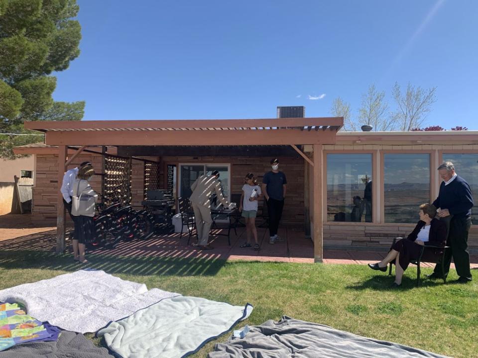 Family at a house with picnic blankets laid out.