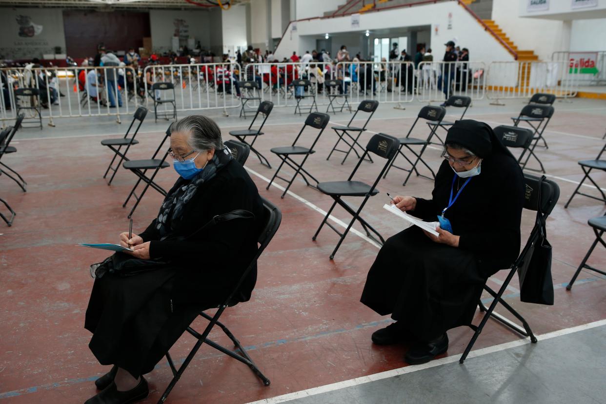 Nuns Tomasa Lopez, 71, left, and Maria Lopez, 79,  fill out forms before receiving a second dose of the Sinovac COVID-19 vaccine at the Americas Cultural Center in Ecatepec, Mexico, Saturday, April 3, 2021.