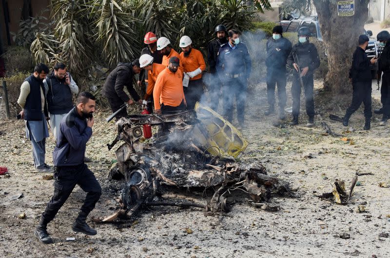 Rescue workers and police officers gather at the site of a suicide car bombing in Islamabad