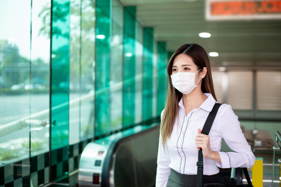 Asian woman with surgical face mask protection - she commutes in the metro or train station