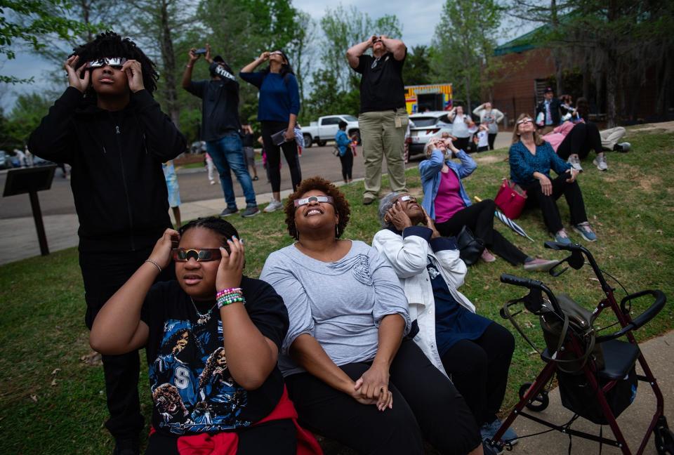 O'Bai Smooth-Bangura, 16; Suraya Smooth-Bangura, 10; Wendy Smooth and her mother Viola Smooth watch the eclipse during an event at the Mississippi Museum of Natural Science in Jackson on Monday. "We came from the path of totality to be with [Viola]," Wendy of Columbus, Ohio, said.