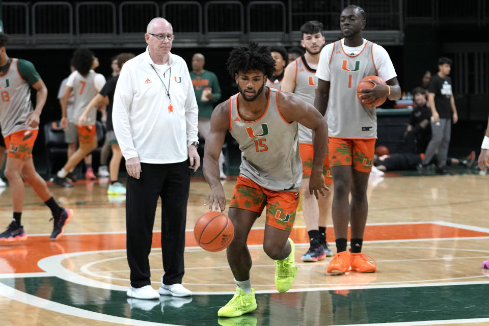 Norchad Omier (15) does drills as head coach Jim Larranaga, left, looks on during practice at media day for the Miami NCAA college basketball team, Monday, Oct. 23, 2023, in Coral Gables, Fla. (AP Photo/Lynne Sladky)