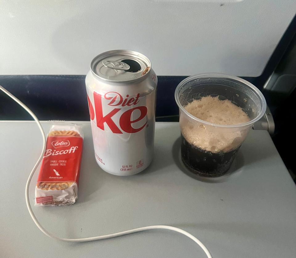 Diet Coke and Biscoff cookies on the tray table.