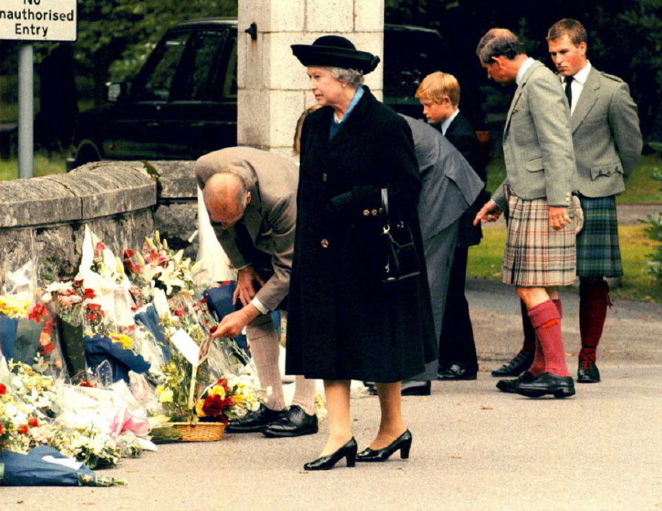 the queen walking the grounds to see the flowers mourners left