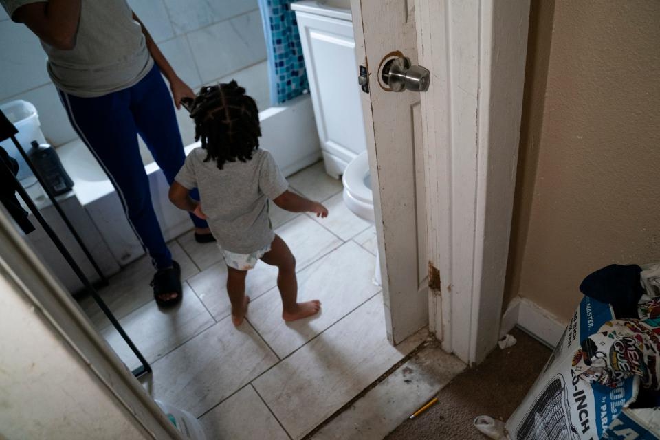 Arica Crowder, 26, shows a door leading into her bathroom that is completely off its hinges of the Detroit apartment she rents Tuesday, Oct. 18, 2022.