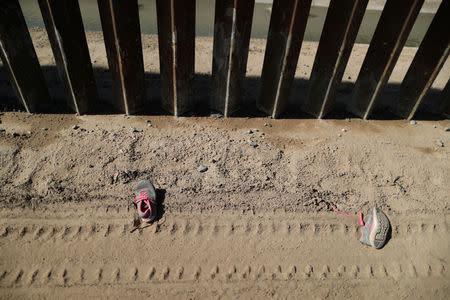 A pair of discarded shoes is seen next to the U.S.-Mexico border fence in El Paso, Texas, U.S., March 6, 2019. REUTERS/Lucy Nicholson/Files