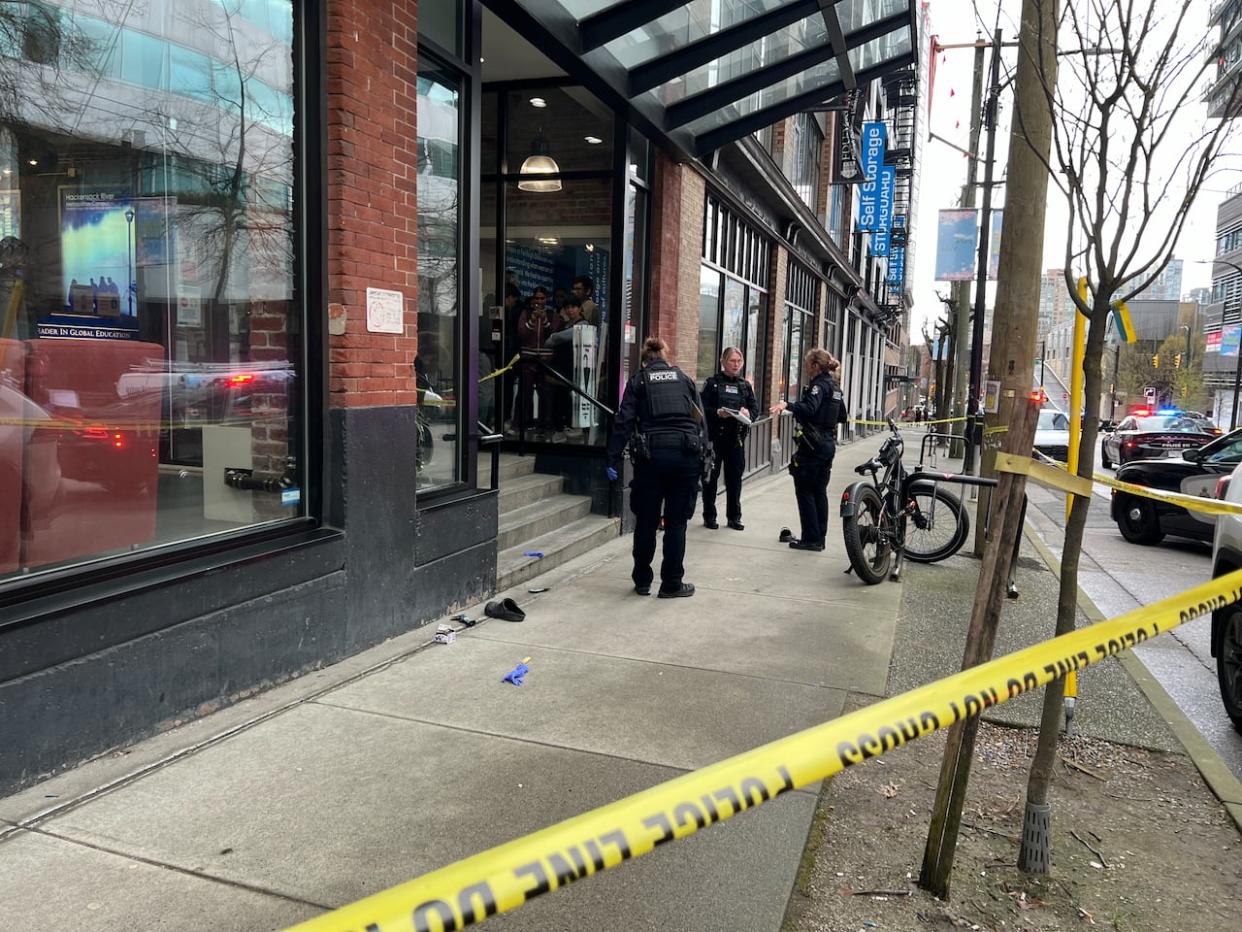 Vancouver police officers are pictured at the scene of what the department called a 'serious assault' on Wednesday. (Yvette Brend/CBC - image credit)