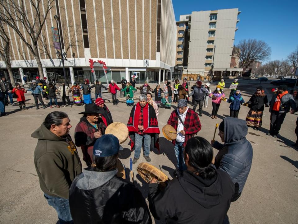 Wet'suwet'en Hereditary Chief Gisdaywa, centre, stands with drummers during a protest against the Royal Bank of Canada’s Annual General Meeting at the Delta Bessborough hotel in Saskatoon on Wednesday, April 5, 2023. (Liam Richards/The Canadian Press - image credit)