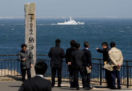 FILE PHOTO: A Japanese Coast Guard vessel PS08 Kariba sails off Cape Nosappu in Nemuro on Japan's Hokkaido island, with part of the islands known as the Northern Territories in Japan and the Southern Kurils, in Russia visible in the background, April 14, 2017. REUTERS/Issei Kato/File Photo