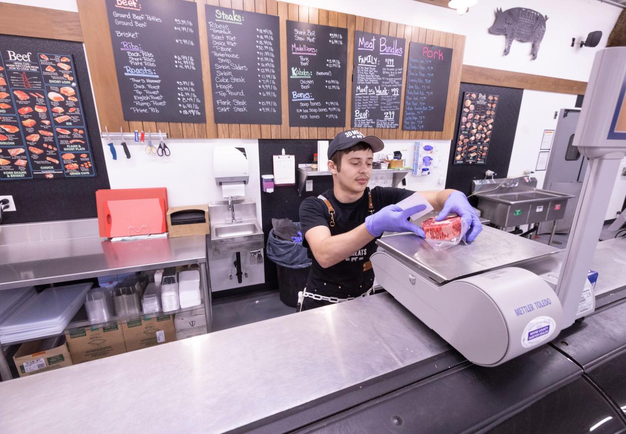 3D Meats manager Logan Haer packages a ribeye steak on Tuesday for a customer at the Dalton store.