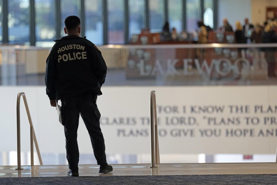 A police officer stands at the top of the steps inside Lakewood Church, Sunday, Feb. 18, 2024, in Houston. Pastor Joel Osteen welcomed worshippers back to Lakewood Church Sunday for the first time since a woman with an AR-style opened fire in between services at his Texas megachurch last Sunday. (AP Photo/David J. Phillip)