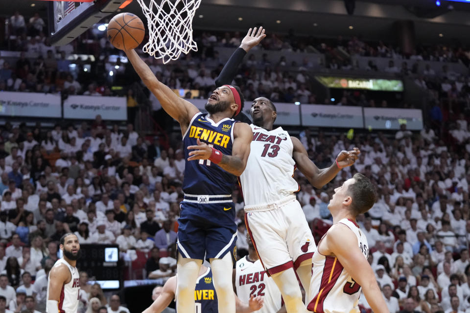 Denver Nuggets forward Bruce Brown (11) drives to the basket as Miami Heat center Bam Adebayo (13) defends during the first half of Game 4 of the basketball NBA Finals, Friday, June 9, 2023, in Miami. (AP Photo/Wilfredo Lee)