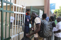 Nigeria civil servants display their COVID-19 vaccines certificates to security officers before they are allowed access to their office in Abuja, Nigeria , Wednesday, Dec. 1, 2021. Nigeria has detected its first case of the omicron coronavirus variant in a sample it collected in October, weeks before South Africa alerted the world about the variant last week, the country's national public health institute said Wednesday. (AP Photo/Gbemiga Olamikan)