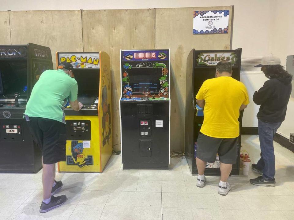 Fox Hamilton, left, and Dan Leon, center, compete on Pac-Man and Galaga during the Arcade Game Gauntlet, while Leon’s son, Dan Leon Jr., watches. The tournament Monday was played on these two machines, as well as Mario Bros. Sonora Slater