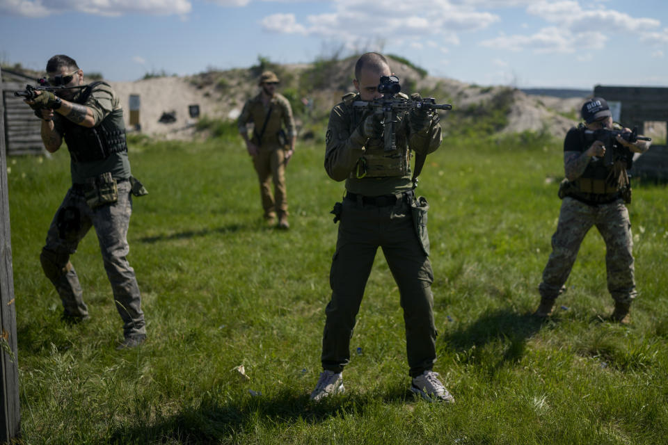 Rapper Viacheslav Drofa, known as Otoy, center, trains with other militia men at a shot range outskirts Kyiv, Ukraine, Tuesday, June 7, 2022. From the battlefronts of Ukraine comes rap music — filled with the anger and indignation of a young generation that, once the fighting is done, will certainly never forget and may never forgive.Ukrainian rapper-turned-volunteer soldier Otoy is putting the war into words and thumping baselines, tapping out lyrics under Russian shelling on his phone, with the light turned low to avoid becoming a target. It helps numb the nerve-shredding stress of combat. (AP Photo/Natacha Pisarenko)